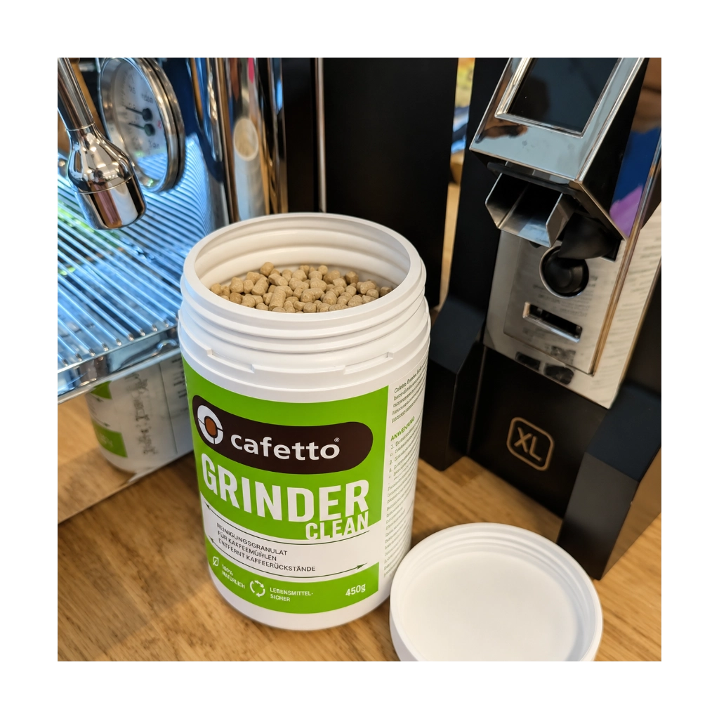 Cafetto Grinder Clean Mühlenreiniger 450 g mit geöffnetem Behälter und Reinigungsgranulat neben einer Espressomühle