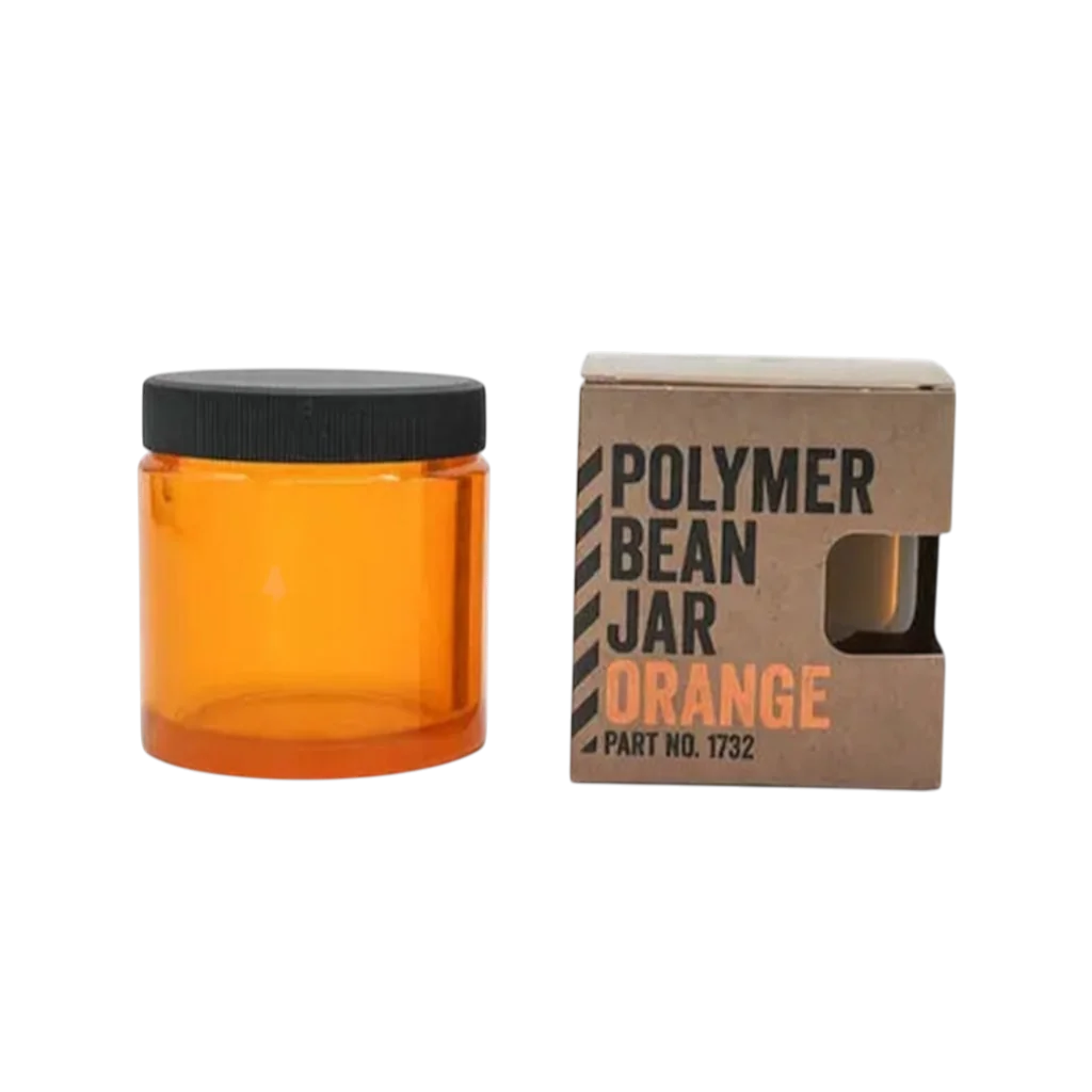 Comandante Bohnenbehälter in orange mit Deckel neben der Verpackung 